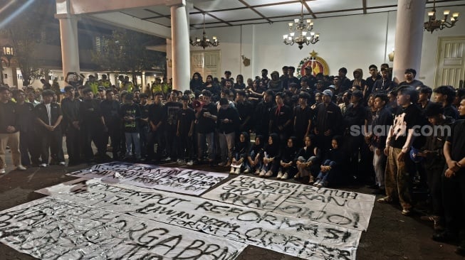 Massa Aliansi Badan Eksekutif Mahasiswa (BEM) DIY menggelar aksi di halaman depan DPRD DIY, pada Jumat sore (19/6/2026). (Suara.com/Hiskia)