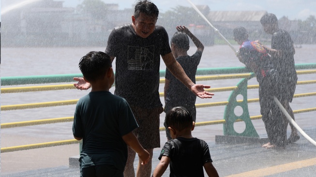 Sejumlah warga Tionghoa bermain air saat perayaan Festival Peh Cun di tepian Sungai Kapuas, Pontianak, Kalimantan Barat, Jumat (19/6/2026). [ANTARA FOTO/Jessica Wuysang/hma]