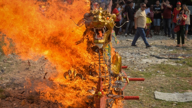 Warga keturunan Tionghoa menyaksikan tradisi pembakaran perahu naga saat perayaan Peh Cun di Kota Tangerang, Banten, Jumat (19/6/2026). [ANTARA FOTO/Putra M. Akbar/hma] 
