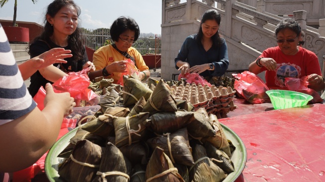 Petugas menyiapkan bakcang (kue ketan isi daging) untuk dibagikan kepada warga saat perayaan Peh Cun di Klenteng Tjoe Hwie Kiong, Kota Kediri, Jawa Timur, Jumat (19/6/2026). [ANTARA FOTO/Prasetia Fauzani/hma]