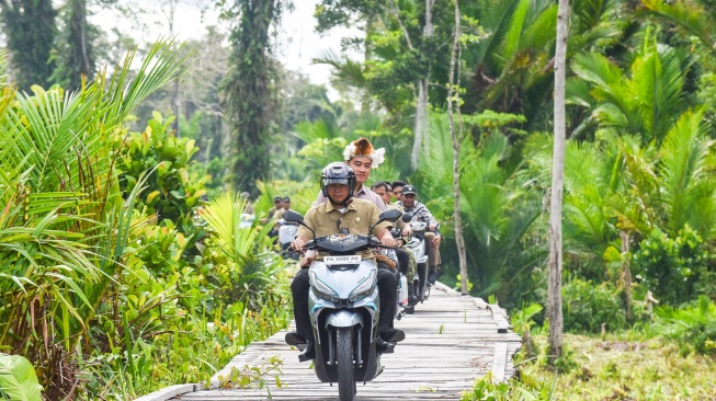 Wakil Presiden Gibran Rakabuming Raka (kedua kiri) naik motor listrik saat kunjungan kerja ke Kabupaten Asmat di Papua Selatan, Minggu (21/6/2026). [ANTARA FOTO/Indrianto Eko Suwarso/agr]