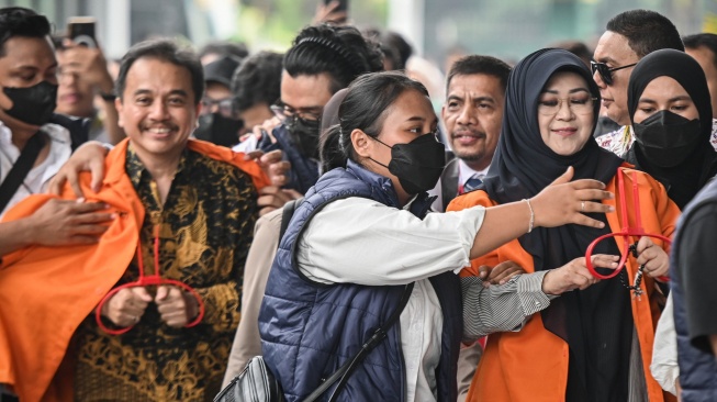 Petugas kepolisian menggiring Roy Suryo (kiri) dan Tifauzia Tyassuma (kanan) ke dalam gedung di Kejaksaan Negeri Jakarta Selatan, Jakarta, Senin (22/6/2026). [ANTARA FOTO/Sulthony Hasanuddin/foc]