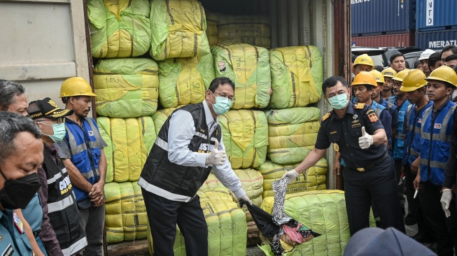 Menteri Keuangan Purbaya Yudhi Sadewa (kiri) dan Dirjen Bea dan Cukai Djaka Budhi Utama (kanan) menunjukkan pakaian bekas impor ilegal (balpres) saat konferensi pers penindakan peti kemas pakaian bekas ilegal di Buffer Area TPS CDC Pelabuhan Tanjung Priok, Jakarta, Selasa (23/6/2026). [ANTARA FOTO/Sulthony Hasanuddin/tom]