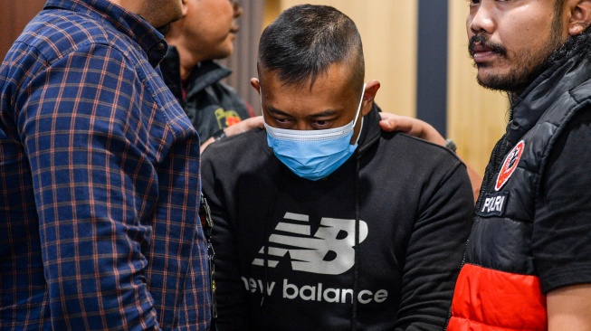 Petugas menggiring tersangka kasus dugaan penyekapan dan penganiayaan berat Taufik Hidayat (tengah) setibanya di Polda Jabar, Bandung, Jawa Barat, Selasa (23/6/2026). [ANTARA FOTO/Raisan Al Farisi/nym]
