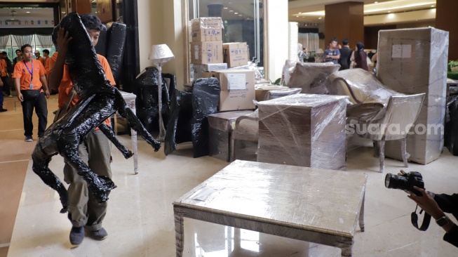 Petugas mengangkut barang ke luar Hotel Sultan, Jakarta, Rabu (24/6/2026). [Suara.com/Alfian Winanto]