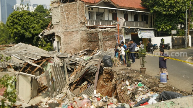 Warga melihat kondisi bangunan yang terdampak tanah longsor di Petamburan, Tanah Abang, Jakarta, Jumat (26/6/2026). [Suara.com/Alfian Winanto]