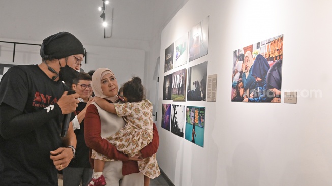 Menteri Komunikasi dan Digital Meutya Hafid (kedua kiri) bersama Direktur Utama Perum LKBN ANTARA Benny Siga Butarbutar (kiri) dan Kurator Pameran Perisai Tunas Fanny Octavianus (ketiga kiri) melihat karya foto saat pameran foto bertajuk Perisai Tunas di ANTARA Heritage Center, Jakarta, Kamis (25/6/2026). [Suara.com/Alfian Winanto]