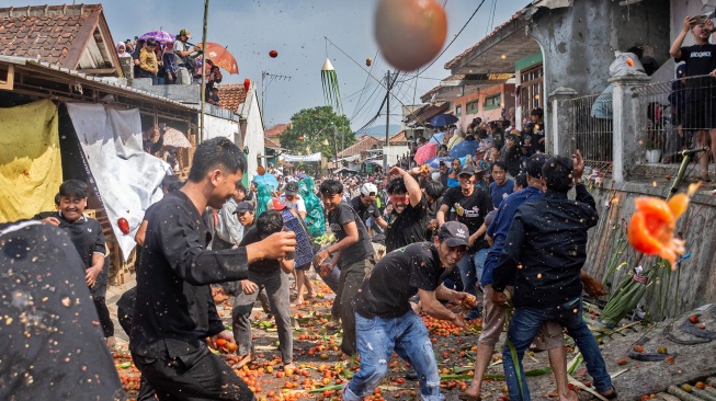 Warga saling melempar tomat busuk saat hajat lembur Festival Perang Tomat 2026 di Kampung Cikareumbi, Lembang, Kabupaten Bandung Barat, Jawa Barat, Jumat (26/6/2026). [ANTARA FOTO/Abdan Syakura/kye]