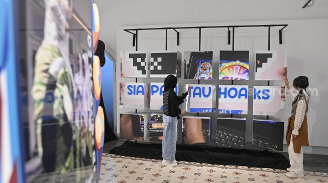 Pengunjung melihat karya foto saat pameran foto bertajuk Perisai Tunas di ANTARA Heritage Center, Jakarta, Kamis (25/6/2026). [Suara.com/Alfian Winanto]