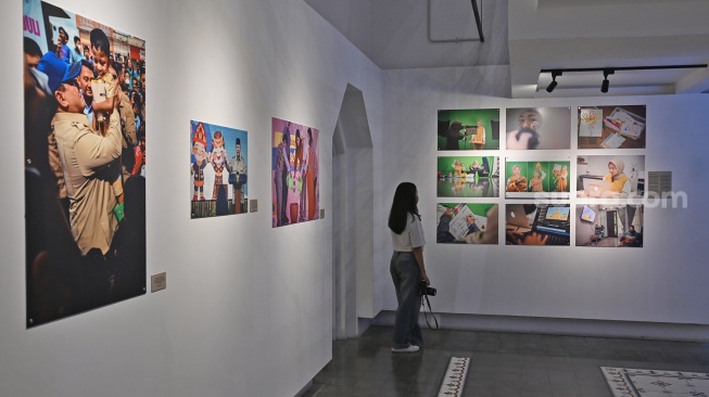 Pengunjung melihat karya foto saat pameran foto bertajuk Perisai Tunas di ANTARA Heritage Center, Jakarta, Kamis (25/6/2026). [Suara.com/Alfian Winanto]