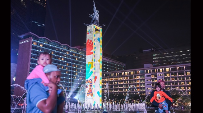 Warga menyaksikan video mapping pada Monumen Selamat Datang saat puncak perayaan HUT ke-499 Kota Jakarta, di kawasan Bundaran Hotel Indonesia, Jakarta, Sabtu (27/6/2026). [ANTARA FOTO/M Risyal Hidayat/wsj]