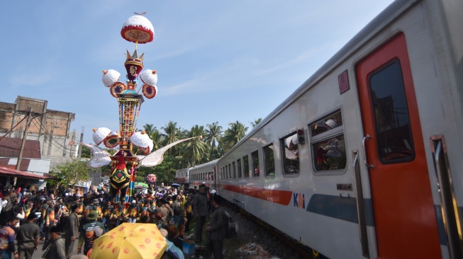 Kereta api melintas saat Tabuik dibawa ke laut pada puncak Pesona Budaya Hoyak Tabuik 2026 di Pantai Gandoriah, Pariaman, Sumatera Barat, Minggu (28/6/2026). [ANTARA FOTO/Fitra Yogi/sgd]
