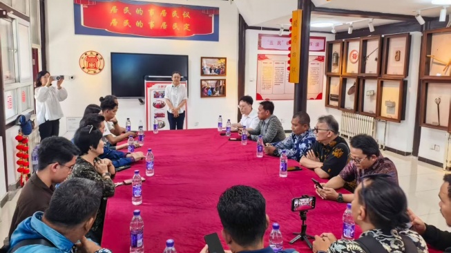 Wakil Sekretaris Komunitas Caochang, Subdistrik Qianmen, Distrik Dongcheng, Tian Tian (tengah, berdiri) menjelaskan terkait musyawarah sebagai sarana penyelesaian masalah antarwarga, Jumat (26/6/2026). [Ist]