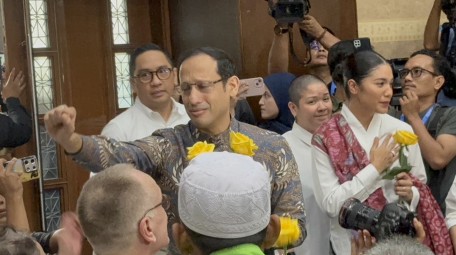 Mendikbudristek Nadiem Makarim menerima bunga mawar kuning dari pendukunya jelang sidang pembacaan putusan dalam kasus dugaan korupsi chromebook di Pengadilan Tipikor Jakarta, Selasa (30/6/2026). [Suara.com?/Dea]