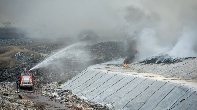 Petugas pemadam kebakaran berusaha memadamkan api di Tempat Pembuangan Akhir (TPA) Jatiwaringin, Kabupaten Tangerang, Banten, Selasa (30/6/2026). [ANTARA FOTO/Putra M. Akbar/YU]
