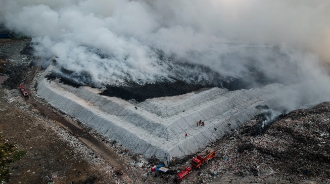 Foto udara petugas pemadam kebakaran berusaha memadamkan api di Tempat Pembuangan Akhir (TPA) Jatiwaringin, Kabupaten Tangerang, Banten, Selasa (30/6/2026). [ANTARA FOTO/Putra M. Akbar/YU]