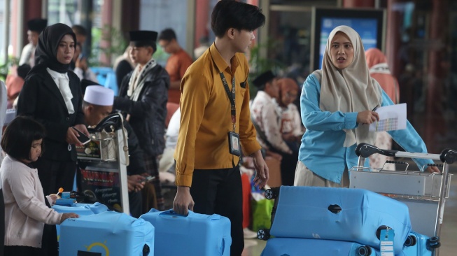 Petugas menata koper bawaan jamaah calon umrah di Terminal 2 F Khusus Umrah dan Haji Bandara Soekarno-Hatta, Tangerang, Banten, Rabu (1/7/2026). [ANTARA FOTO/Muhammad Iqbal/tom]