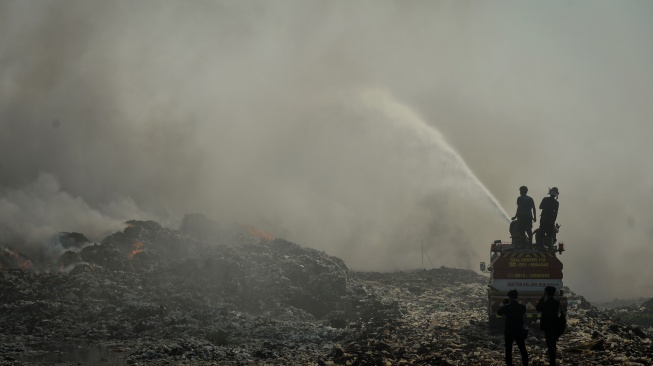 Petugas pemadam kebakaran berusaha memadamkan api di Tempat Pembuangan Akhir (TPA) Jatiwaringin, Kabupaten Tangerang, Banten, Rabu (1/7/2026). [ANTARA FOTO/Putra M. Akbar/YU]