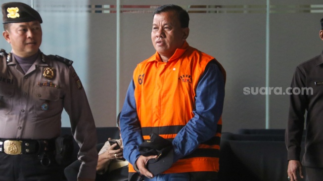 Bupati Kuantan Singingi Suhardiman Amby berjalan menuju mobil tahanan usai menjalani pemeriksaan di Gedung Merah Putih KPK, Jakarta, Rabu (1/7/2026). [Suara.com/Alfian Winanto]
