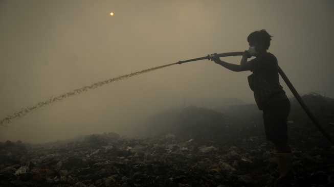 Petugas pemadam kebakaran berusaha memadamkan api di Tempat Pembuangan Akhir (TPA) Jatiwaringin, Kabupaten Tangerang, Banten, Rabu (1/7/2026). [ANTARA FOTO/Putra M. Akbar/YU]