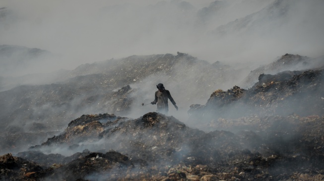 Pemulung memilah sampah pada tumpukan sampah yang terbakar di Tempat Pembuangan Akhir (TPA) Jatiwaringin, Kabupaten Tangerang, Banten, Rabu (1/7/2026). [ANTARA FOTO/Putra M. Akbar/YU]