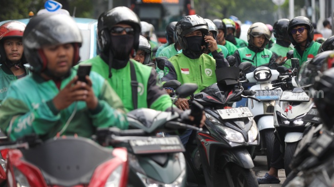Pengemudi ojek online menjemput penumpang di seberang Stasiun Palmerah, Jakarta, Kamis (2/7/2026). [Suara.com/Alfian Winanto]