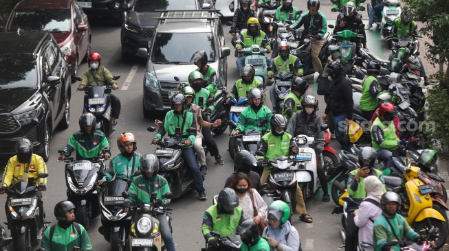 Pengemudi ojek online menjemput penumpang di seberang Stasiun Palmerah, Jakarta, Kamis (2/7/2026). [Suara.com/Alfian Winanto]