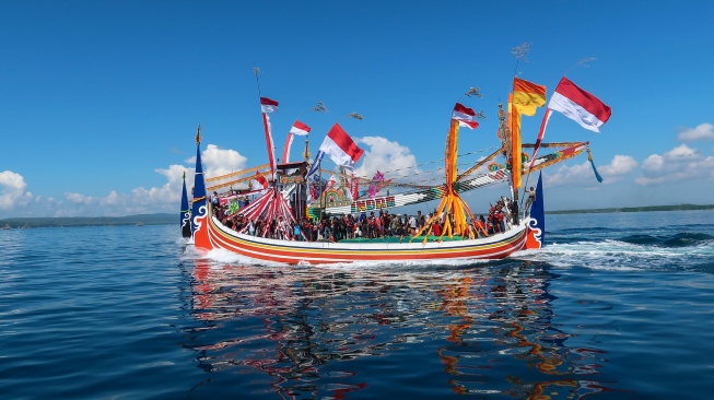 Sejumlah warga mengikuti prosesi ritual Petik Laut menggunakan kapal slerek yang dihias di Perairan Muncar, Banyuwangi, Jawa Timur, Rabu (1/7/2026). [ANTARA FOTO/Budi Candra Setya/YU]