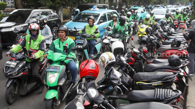 Pengemudi ojek online menjemput penumpang di seberang Stasiun Palmerah, Jakarta, Kamis (2/7/2026). [Suara.com/Alfian Winanto]