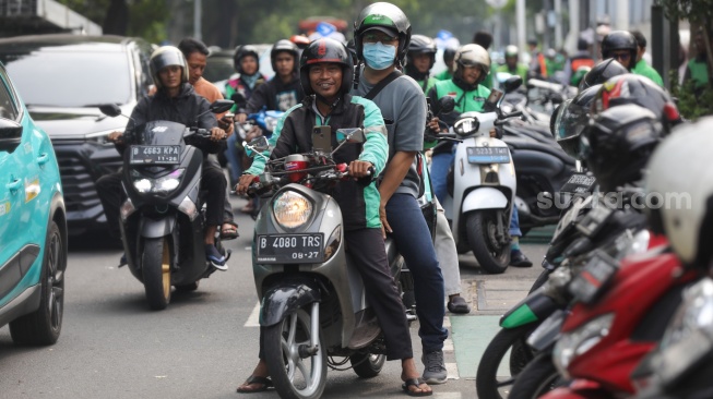 Pengemudi ojek online menjemput penumpang di seberang Stasiun Palmerah, Jakarta, Kamis (2/7/2026). [Suara.com/Alfian Winanto]
