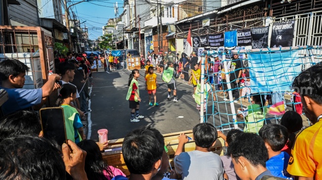 Sejumlah anak berebut bola saat bertanding di Jalan Sawah Lio, Tambora, Jakarta, Minggu (7/6/2026). Turnamen yang bertajuk Liga Akamsi tersebut digelar sebagai wadah penyaluran bakat (ANTARA FOTO/Galih Pradipta)
