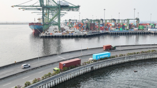 Foto udara truk mengangkut peti kemas melintas di Dermaga Pelabuhan Tanjung Priok, Jakarta, Kamis (2/7/2026). [ANTARA FOTO/M Risyal Hidayat/nym]
