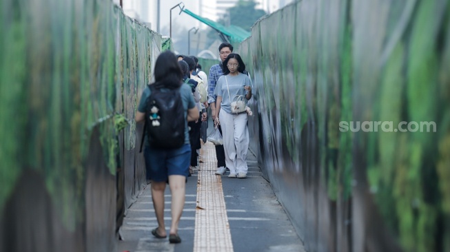 Warga berjalan menyusuri jalur pedestrian darurat di kawasan Bundaran HI, Jakarta, Senin (6/7/2026). [Suara.com/Alfian Winanto]