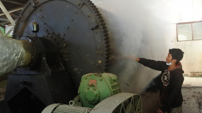 Seorang pekerja mengeringkan biji kopi jenis robusta di mesin pengering di Perusahaan Daerah Perkebunan (PDP) Kahyangan Jember, Jawa Timur, Senin (6/7/2026). [ANTARA FOTO/Seno/wsj]