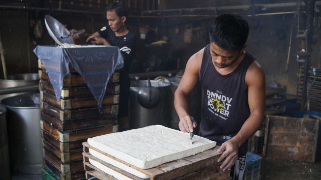 Pekerja menyelesaikan pembuatan tahu di Pabrik Rumahan kawasan Mampang, Jakarta, Selasa (7/7/2026). [Suara.com/Alfian Winanto]