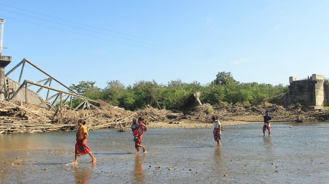 Sejumlah warga menyeberang sungai akibat putusnya jembatan Termanu di Kecamatan Amfoang, Kabupaten Kupang, Nusa Tenggara Timur, Selasa (7/7/2026). [ANTARA FOTO/Kornelis Kaha/sgd]