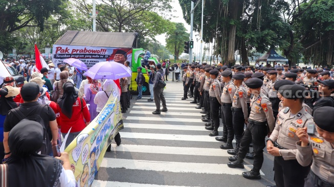 Massa aksi saat berunjuk rasa mendukung program MBG di Jakarta, Rabu (8/7/2026). [Suara.com/Alfian Winanto]