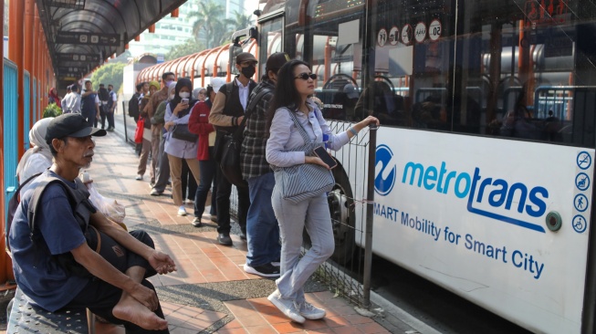Warga antre menaiki bus Transjakarta di Terminal Blok M, Jakarta, Kamis (9/7/2026). [Suara.com/Alfian Winanto]
