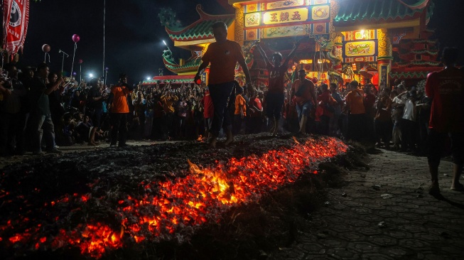 Warga keturunan Tionghoa berjalan di atas bara api saat mengikuti tradisi Tahwee dalam perayaan Shejit Dewa Bumi di Klenteng Ngo Kok Ong, di Cibarusah, Kabupaten Bekasi, Jawa Barat, Rabu (8/7/2026). [ANTARA FOTO/Darryl Ramadhan/kye]