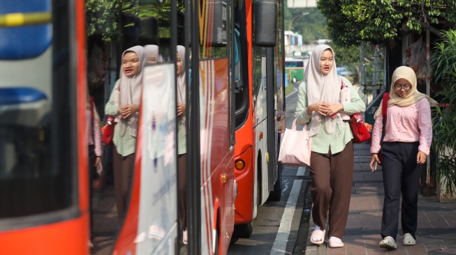 Warga antre menaiki bus Transjakarta di Terminal Blok M, Jakarta, Kamis (9/7/2026). [Suara.com/Alfian Winanto]