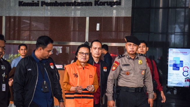 Tersangka kasus dugaan gratifikasi dalam pengadaan barang dan jasa Ma'ruf Cahyono (tengah) mengenakan rompi tahanan usai menjalani pemeriksaan di Gedung Merah Putih KPK, Jakarta, Kamis (9/7/2026). [ANTARA FOTO/Reno Esnir/sth/foc]