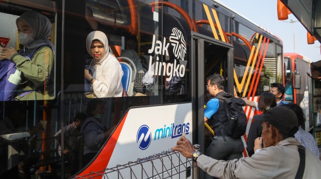 Warga antre menaiki bus Transjakarta di Terminal Blok M, Jakarta, Kamis (9/7/2026). [Suara.com/Alfian Winanto]