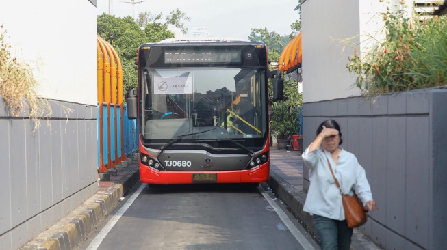 Warga antre menaiki bus Transjakarta di Terminal Blok M, Jakarta, Kamis (9/7/2026). [Suara.com/Alfian Winanto]