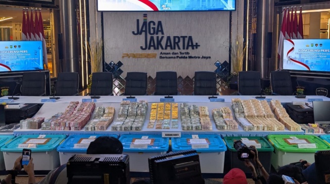 Barang bukti 74 kilogram emas batangan, tumpukan uang rupiah, dolar Amerika Serikat, hingga dolar Singapura dipamerkan jelang konferensi pers di Gedung Promoter Polda Metro Jaya, Jakarta, Jumat (10/7/2026) malam.