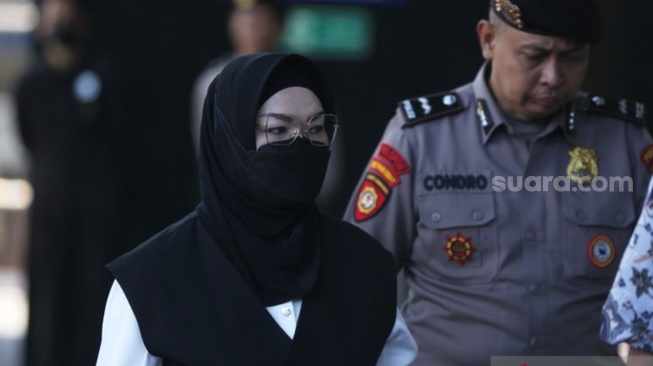Bupati Sukoharjo Etik Suryani (kiri) dikawal petugas saat tiba untuk menjalani pemeriksaan di Gedung Merah Putih KPK, Jakarta, Jumat (10/7/2026). Etik Suryani ditangkap bersama empat orang lainnya dalam operasi tangkap tangan (OTT) KPK terkait dugaan pemerasan terhadap para perangkat daerah di Kabupaten Sukoharjo. (ANTARA FOTO/Reno Esnir)