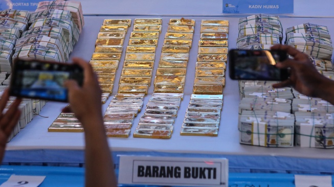 Wartawan memfoto barang bukti emas dan sejumlah uang saat ditampilkan pada konferensi pers di Polda Metro Jaya, Jakarta, Jumat (10/7/2026). [ANTARA FOTO/Asprilla Dwi Adha/foc]