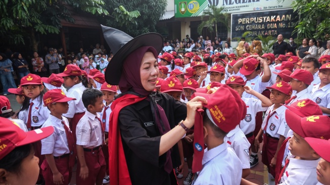 Seorang guru mengenakan kostum bertema serial novel Harry Potter sambil membetulkan topi siswa baru saat pembukaan Masa Pengenalan Lingkungan Sekolah (MPLS) di SD Negeri Cemara 2 Solo, Jawa Tengah, Senin (13/7/2026). [ANTARA FOTO/Maulana Surya/tom]