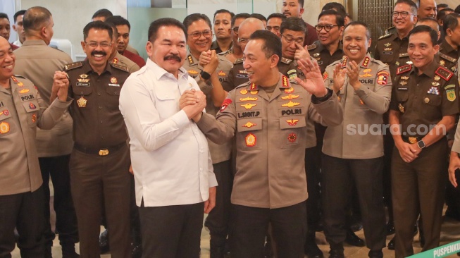 Jaksa Agung ST Burhanuddin (kiri) dan Kapolri Jenderal Listyo Sigit Prabowo (kanan) bersalaman sebelum memberikan keterangan pers di Gedung Kejaksaan Agung RI, Jakarta, Senin (13/7/2026). [Suara.com/Alfian Winanto]