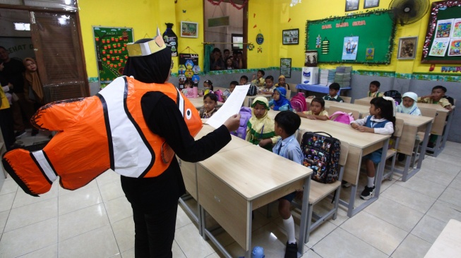 Seorang guru mengecek kehadiran pelajar di kelas Sekolah Dasar Negeri (SDN) Kaliasin I, Surabaya, Jawa Timur, Senin (13/7/2026).  [ANTARA FOTO/Didik Suhartono/tom]