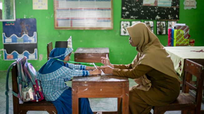 Seorang guru mengajar satu siswa baru saat Masa Pengenalan Lingkungan Sekolah (MPLS) di SD Negeri Cepokosawit II, Boyolali, Jawa Tengah, Senin (13/7/2026). [ANTARA FOTO/Mohammad Ayudha/tom]
